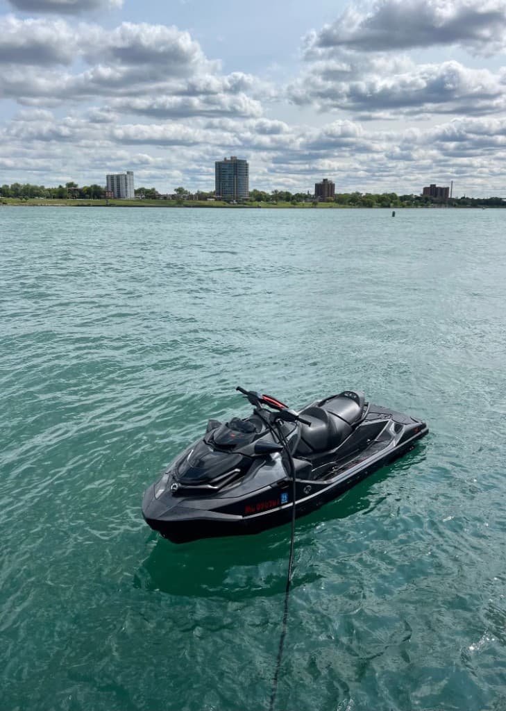 Premium Sea-Doo jet ski on turquoise water with the Detroit skyline behind