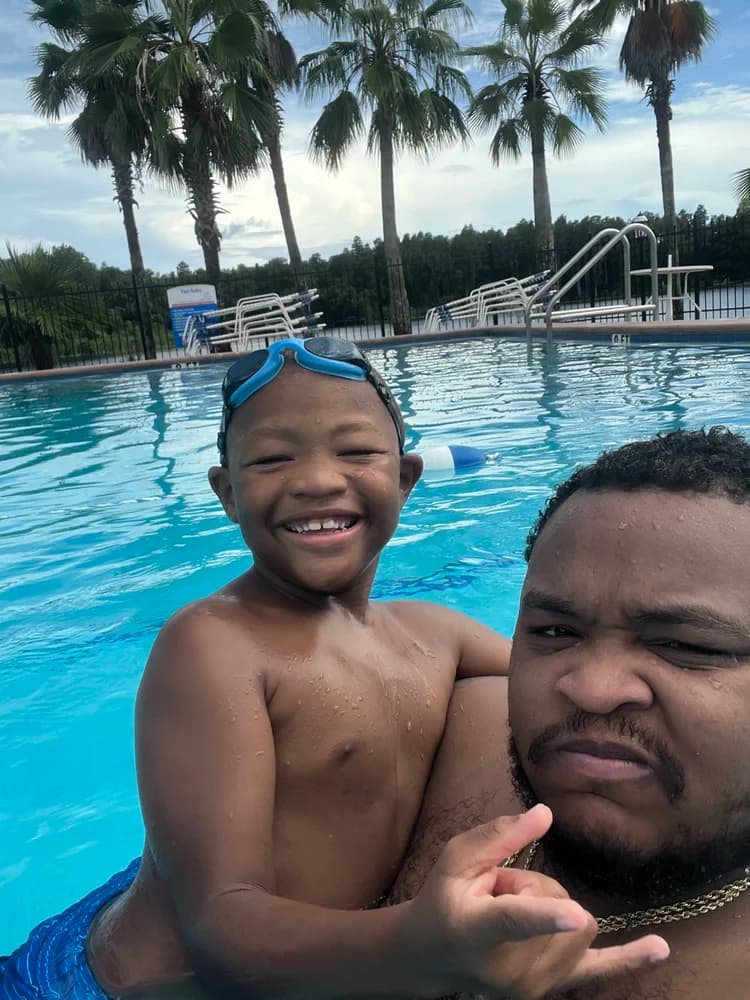 Josh and Junior smiling together in a swimming pool
